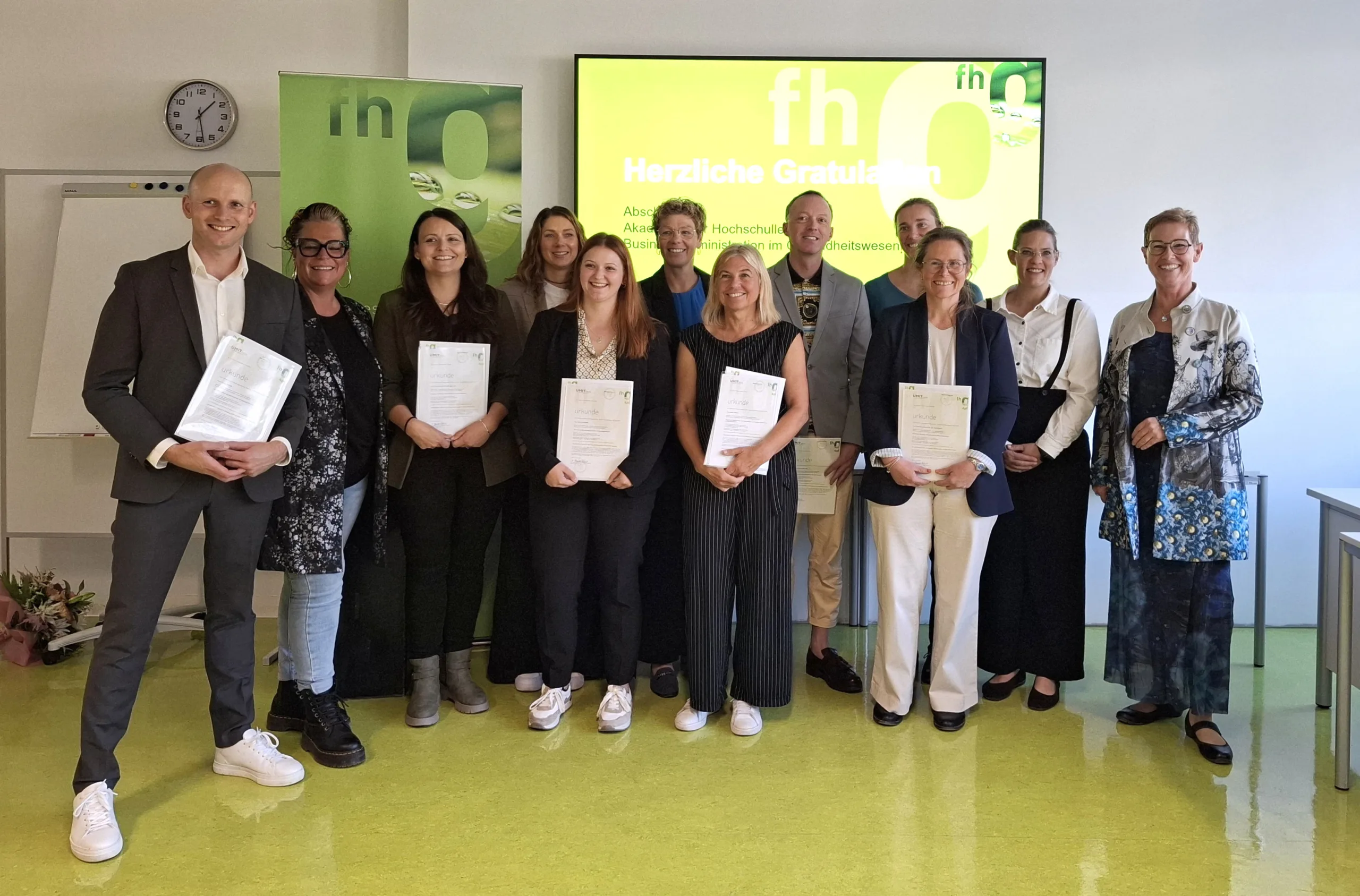 Gruppenfoto der Teilnehmer:innen des Hochschullehrgangs Business Administration im Gesundheitswesen mit Lehrgangsleiterin Eva Maria Jabinger an der fh gesundheit